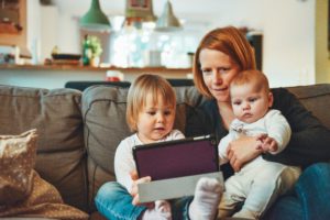 Mom and children on couch with ipad