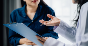 Primary care provider reviewing paperwork with a patient during a visit.